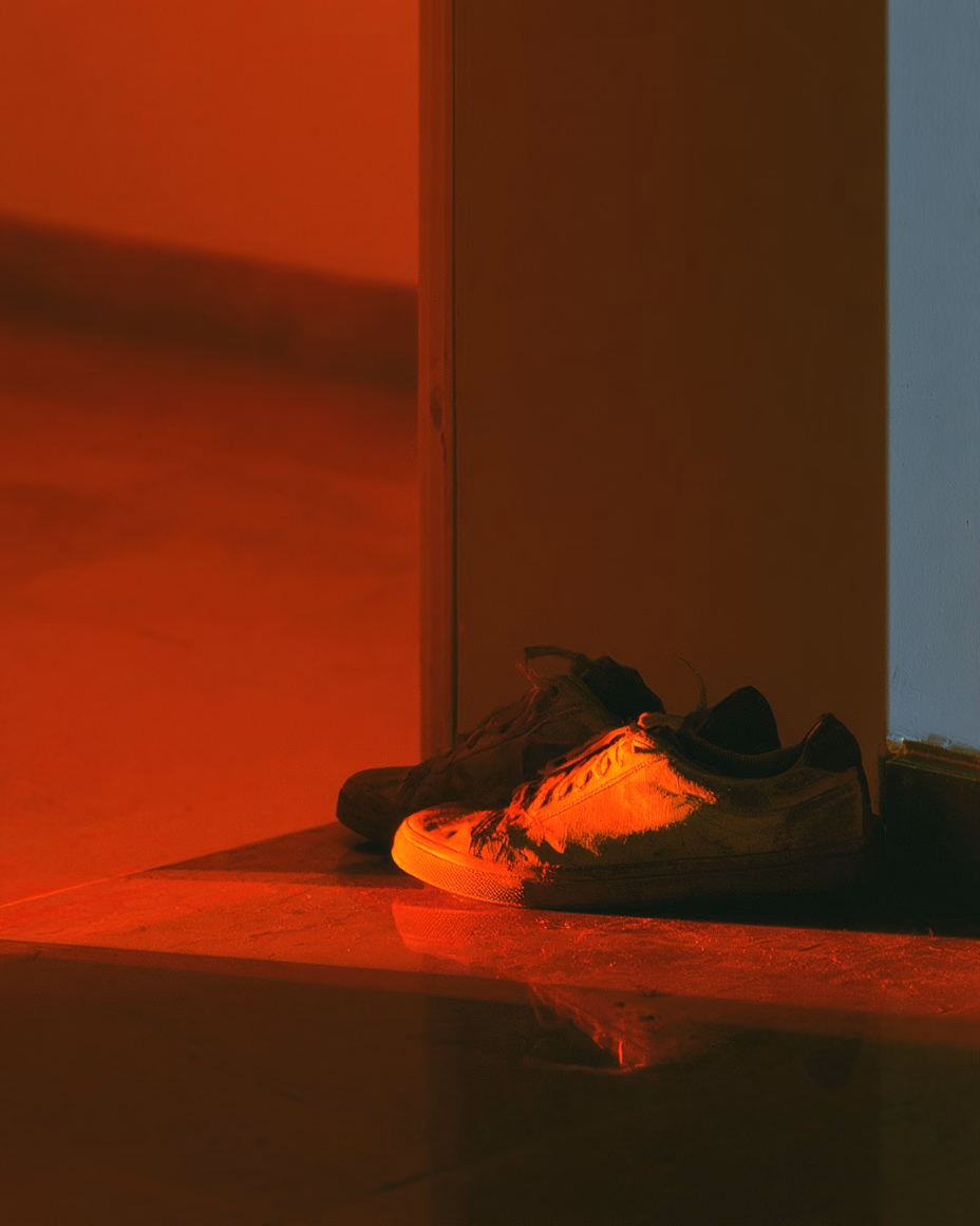Laufschuhe an der Tuer im Daemmerlicht